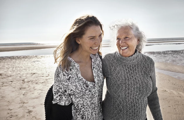 Mutter und Tochter gehen am Strand spazieren.