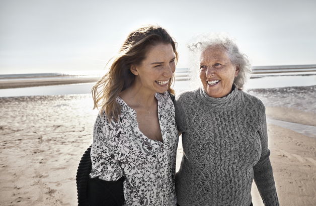 Mutter und Tochter gehen am Strand spazieren.