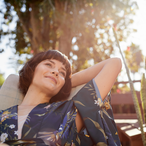 Frau entspannt in einer Hängematte in der Sonne.