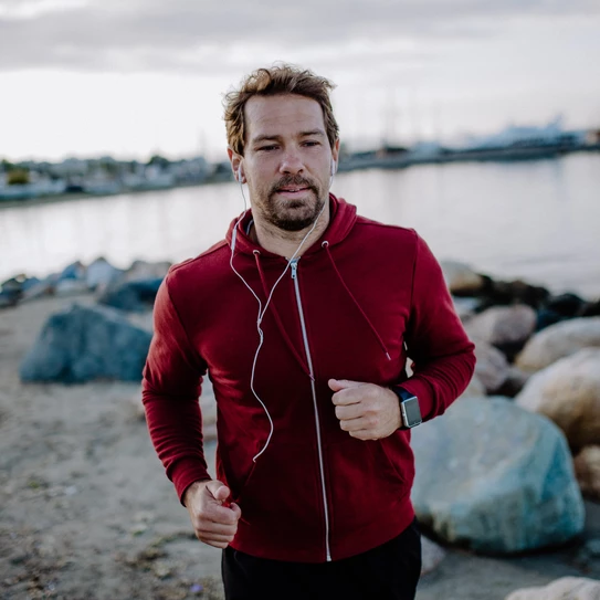 Sportlicher Mann joggt am Strand.