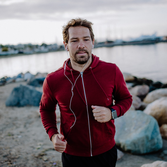 Sportlicher Mann joggt am Strand.