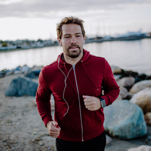 Sportlicher Mann joggt am Strand.